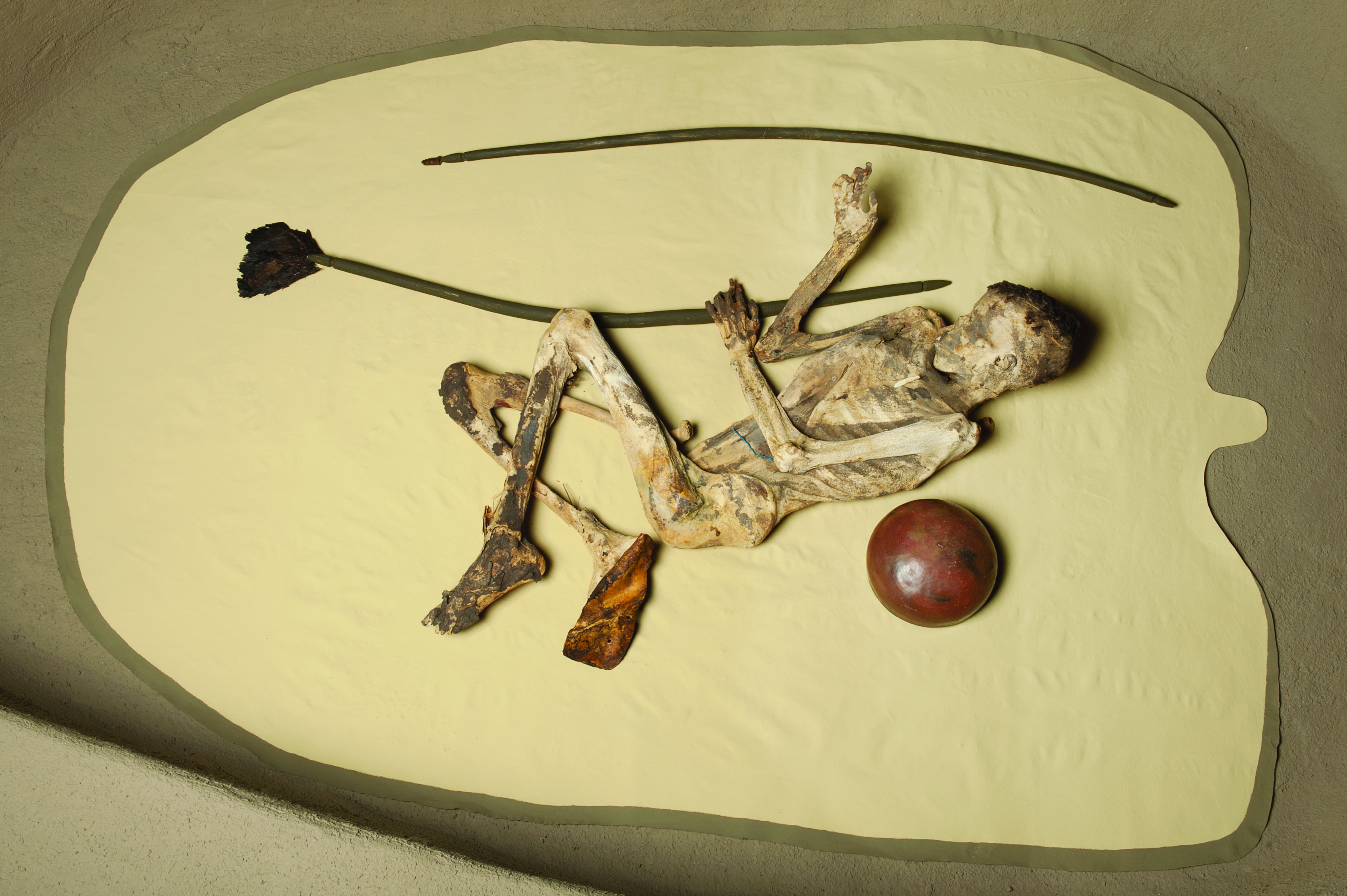 Reconstruction of the grave of the mummified archer excavated by Bonnet (1982), made with the original natural mummy, pottery and plume of ostrich feathers (Kerma ancien II, 2300-2150 BC)